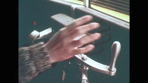 1970s: Bus driver pulls lever to close door. Reflection of bus driver and Stock Footage 81112046