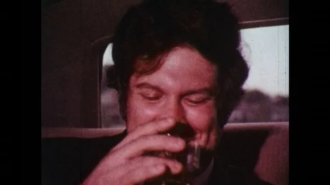 1970s: Businessman in car raises glass, shakes head, car pulls away, kids stand Stock Footage
