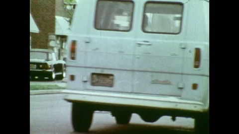 1970s: Car drives on road. Car parks in front of fire hydrant. Three men exit Stock Footage