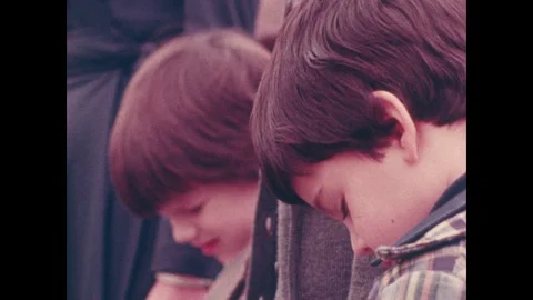 1970s: Children look down during graveside funeral. Adults look down during Stock Footage 101999300