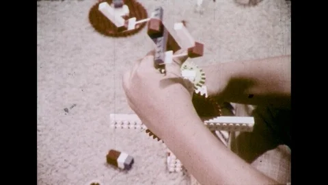 1970s: Child's hands put Lego pieces together, move pieces. Stock Footage