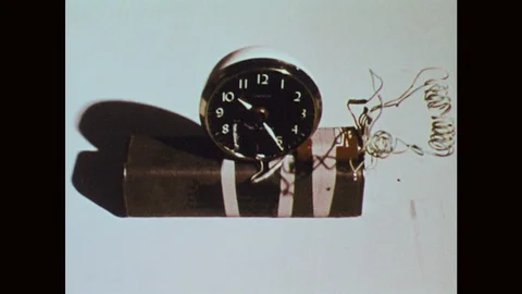 1970s: Clock attached to object with wires. Man pulls inside compartment open, Video stock 121590480