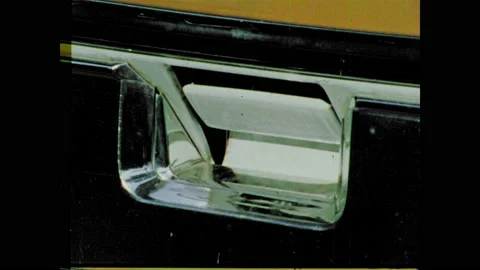 1970s: Close up, hand pulls handle, zoom out, man loads tool boxes into back of Vidéo 135201468