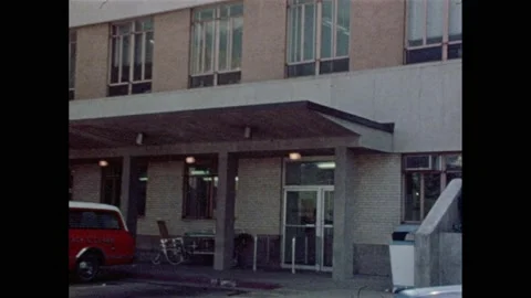 1970s DALLAS: Parkland Memorial Hospital.  Door to emergency room.  Young woman Stock Footage