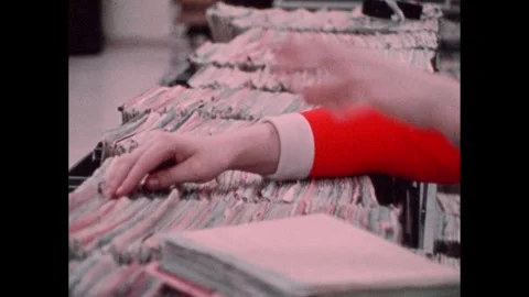 1970s: Data entry computer and screen. Woman files. Yellow Pages Buying Guide. Stock-Footage 241429984