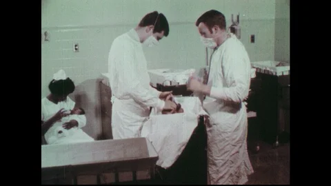 1970s: Doctors examine newborn in hospital. Nurse feeds newborn in hospital. Stock Footage