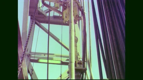 1970s: Drill pipe and coupling lowers through the hole in the oil rig platform Video stock 90297261