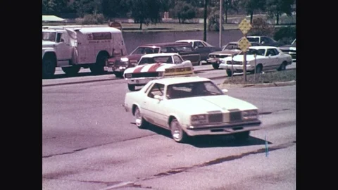 1970s: Driver Education car turns in intersection. POV back seat over driver's Stock Footage