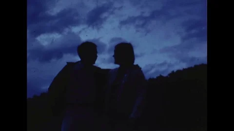 1970s era Super 8 Home Movie Couple Kissing in Silhouette Stock Footage