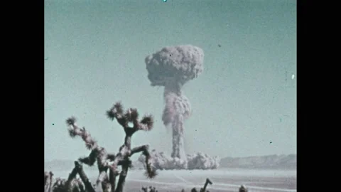 1970s: Explosive atomic bomb mushroom cloud emerges amidst a barren desert, Stock Footage 236927153