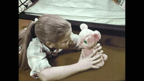 1970s: girl finding stuffed animal under bed, folding clothes into drawers, Stock Footage