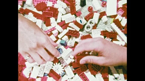 1970s: Hands sort and stack Legos. Baby hand holds crib railing. Baby stands in Stock Footage 89373687