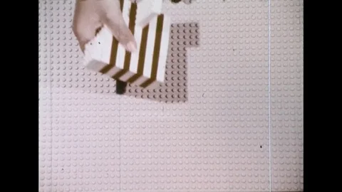 1970s: High angle view, child's hands put Lego pieces on board / Close up, hands Stock Footage 74441379