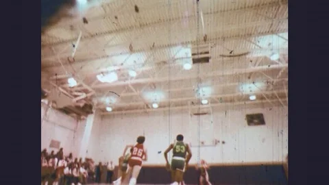 1970s: High school basketball game. Players run around the court and sit on Stock Footage 77252953