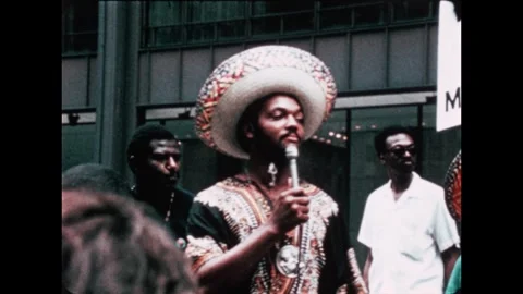 1970s: Jesse Jackson speaks to a crowd. Man makes speech on stage. Audience Stock Footage 267478488
