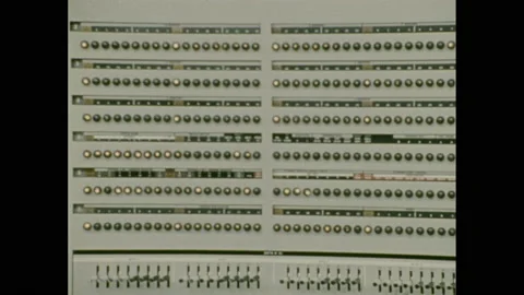 1970s: Lights on server machine flash. Man in server room talks on phone, Stock Footage 157935327