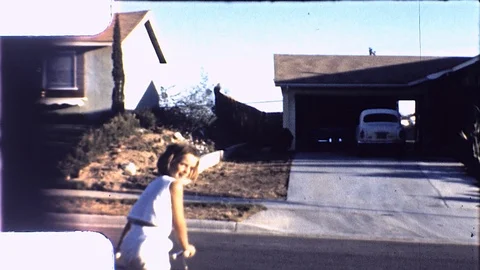 1970s Little Girl Rides Bike Suburb Track House L.A. Vintage Old Film Home Movie Stock Footage