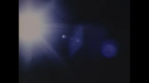 1970s: Low angle view, satellite passes through light / Astronauts read Stock Footage 74712730