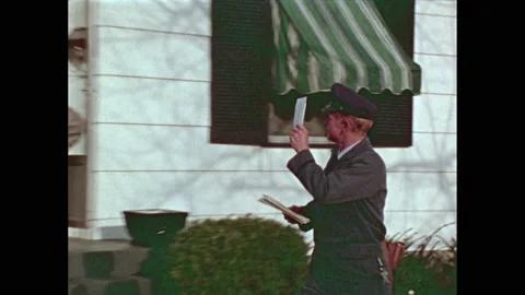 1970s: Mailman puts mail in box, walks away, waves to people on porch. Man Stock Footage 232327182