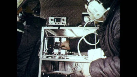 1970s: Man adjusts dials on machine inside plane. Men drive pickup truck through Video stock 86810545