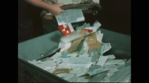 1970s: Man dumps mailbag into bin. Letters travel along conveyor. Mailroom, boy Stock Footage 192245009
