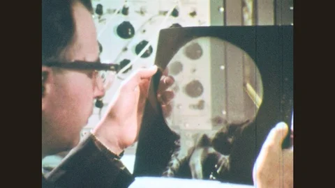 1970s: Man holds up x-ray of skull. Man holds image. Man points. Men talk. Stock Footage