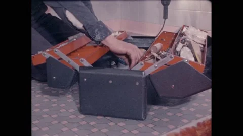 1970s: Man opens toolbox underneath sink inside house, takes out wrench and Stock Footage 238927915
