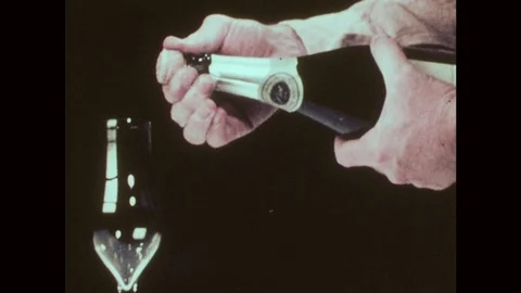 1970s: Man pops cork from champagne bottle, champagne explodes out of bottle, Stock Footage