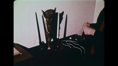1970s - A man prays to a devil statue. Video stock 74718225