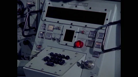 1970s: Man presses buttons on control panel.  Lights change.  Trailer on truck. Stock Footage 159168256