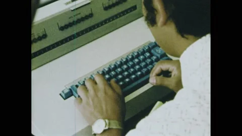 1970s: Man pressing buttons on computer console. Hands typing at keyboard. Stock Footage 164544359
