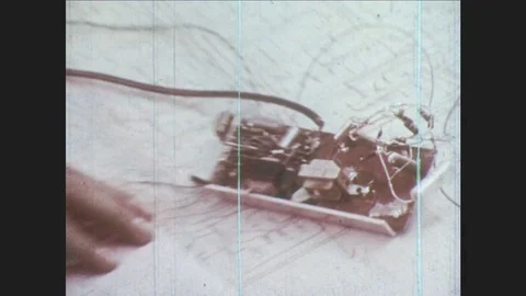 1970s: Man takes notes while looking at circuit board. Man solders circuits Stock Footage 80066051