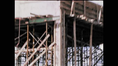 1970s: Man working on construction site, zoom out to crane moving. Men working Stock Footage 135201242