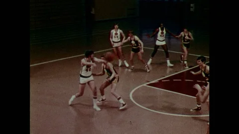1970s: Men bump into one another and commit personal fouls on basketball court. Video stock 127661243