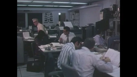 1970s: Men work in office, answer phones, and type on computers. Stock Footage