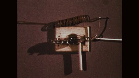 1970s: Mercury switch component. Man tilts switch, building explodes. Policemen Stock Footage 121590510
