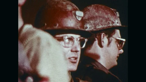 1970s: Miners ride down in elevator.  Man opens gate and workers walk out.  Men Video stock 92049641