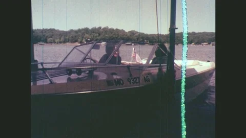 1970s: Motorboat Reverses From Dock. Man Drives Boat With Three Teen Passengers Stock Footage