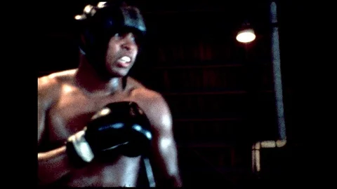 1970s: Muhammed Ali boxes with another man in ring. Stock Footage 112427737