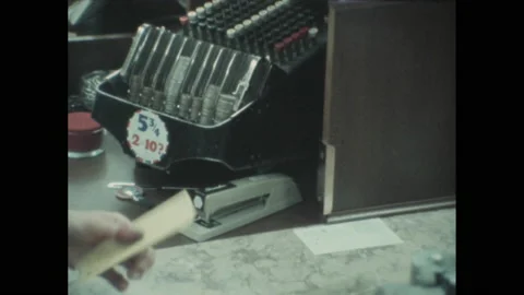 1970s: Office building. Bank teller counts, hands money to person at counter. Stock Footage 142923079