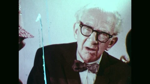1970s: Old man talking. Man in lab coat talks to people in front of him. Old Stock Footage 102002435