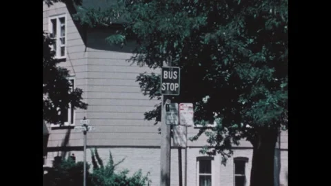 1970s: Papers dropping from machine. Bus stop, zoom out to bus on road. Hands Stock Footage 268626122