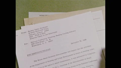 1970s: Papers placed in stack on table, press releases. Library, man sits at Stock Footage 143982342