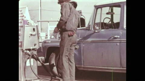 1970s: Person puts gas pump in tank of car at gas station. McDonalds. Cars in Stock Footage
