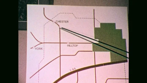 1970s: Pointer gestures to streets on map. Close up of woman, zoom out to people Stock Footage 102741644