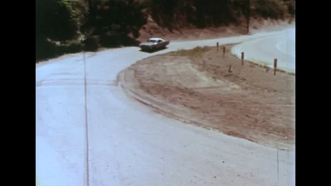 1970s - Police chase teenagers in speeding car down mountain road. Stock Footage