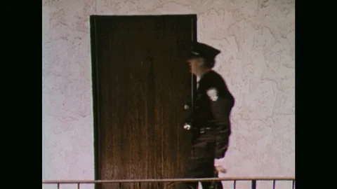 1970s: Police officers walk to door, knock on door. Woman walks through doorway, Stock Footage
