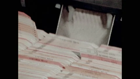 1970s: Programmers work at computer terminals. Data cards spill from computer. Stock Footage 232183009