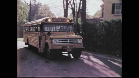1970s: school bus pulling up to local grocer to pick up children waiting outside Stock Footage 134362110