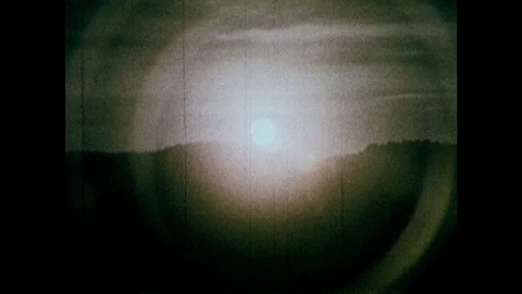 1970s: Sun radiating light in space. Solar panels on Earth. Three residences at Stockbeeldmateriaal 86774715